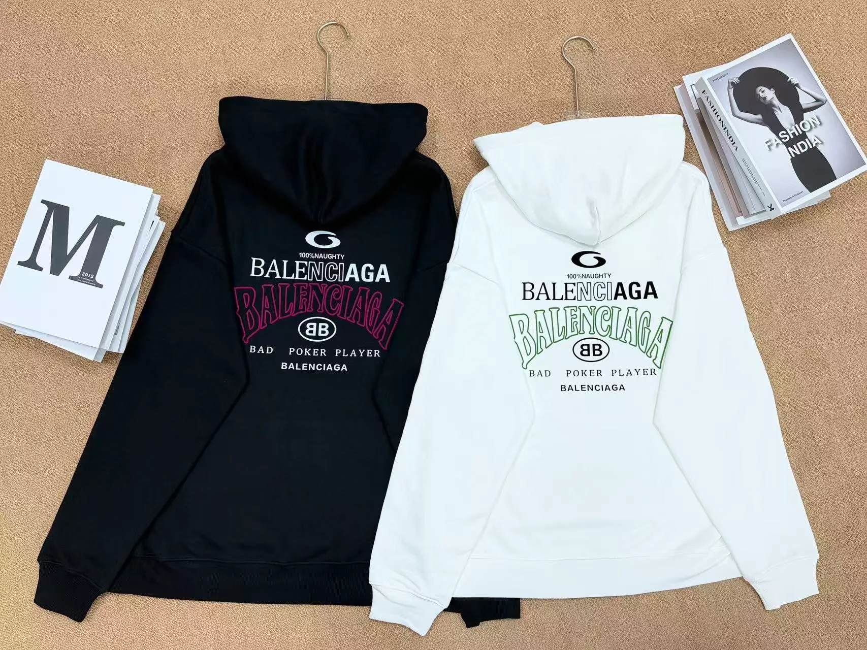 No. 2208 Style: Balenciaga Retro lettered hooded sweatshirt Color: Black, Cream White Version: Oversize loose shoulder, Same style for men and women, lazy and relaxed, covering the flesh and making you look slim Fabric: 430g high gram weight pure cotton terry fabric, soft and thick, with good drape, the upper body is not easy to wrinkle. Design highlights 1. White model: The small logo on the chest is simple and clean, minimalist and low-key style, and the daily Versatile is not picky. 2. Black model: Multi-layered Retro letter printing on the back, white rose red contrasting colors, strong layering, full of trendy atmosphere, the back printing is the visual focus of the entire dress. 3. Classic kangaroo pocket + adjustable drawstring brim, threaded cuffs and hem, Wear-Resistant is not easy to deform, and the workmanship is neatly routed. Wearing scenarios: Suitable for daily outings, commuting, and casual outings. Black is cool and stylish, and looks trendy when paired with jeans, wide-leg pants, and overalls; White is refreshing and simple, suitable for gentle casual style, and can also be worn as a couple's style. Washing and care tips: Machine wash/hand wash with cold water on the reverse side, do not rub the printed area vigorously, and dry in a cool place to avoid exposure to the sun, which may cause the print to crack and fade.